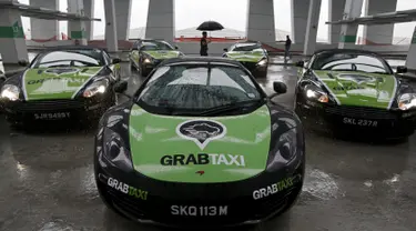 Sejumlah armada GrabTaxi yang terdiri dari tujuh mobil mewah disiapkan untuk pemotretan sebelum beroperasi di Singapura, Selasa (15/9). Mobil-mobil mewah itu akan melayani penumpang secara gratis selama musim balapan F1. (REUTERS/Edgar Su)