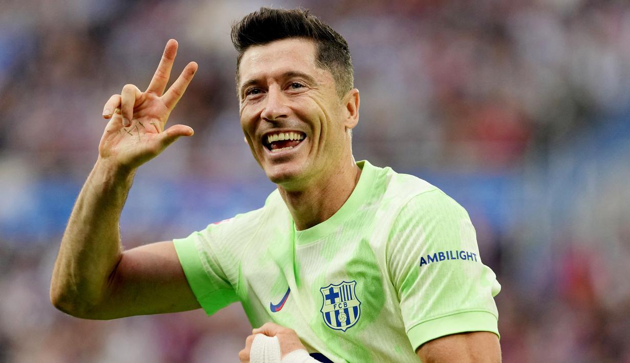 Penyerang Barcelona, Robert Lewandowski, melakukan selebrasi setelah mencetak gol ke gawang Alaves pada laga pekan ke sembilan Liga Spanyol di Stadion Mendizorroza , Minggu (06/10/2024). (AFP/Cesar Manso)