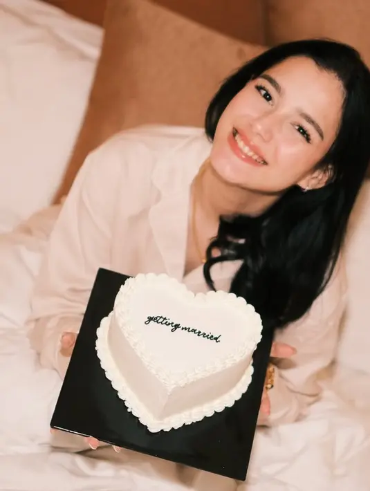 Para sahabat pun memberikan cake love putih bertuliskan “getting merried”. Yasmine Ow pun tampil dengan riasan natural memerlihatkan lipstik glossynya. [@yxsmine.ow]