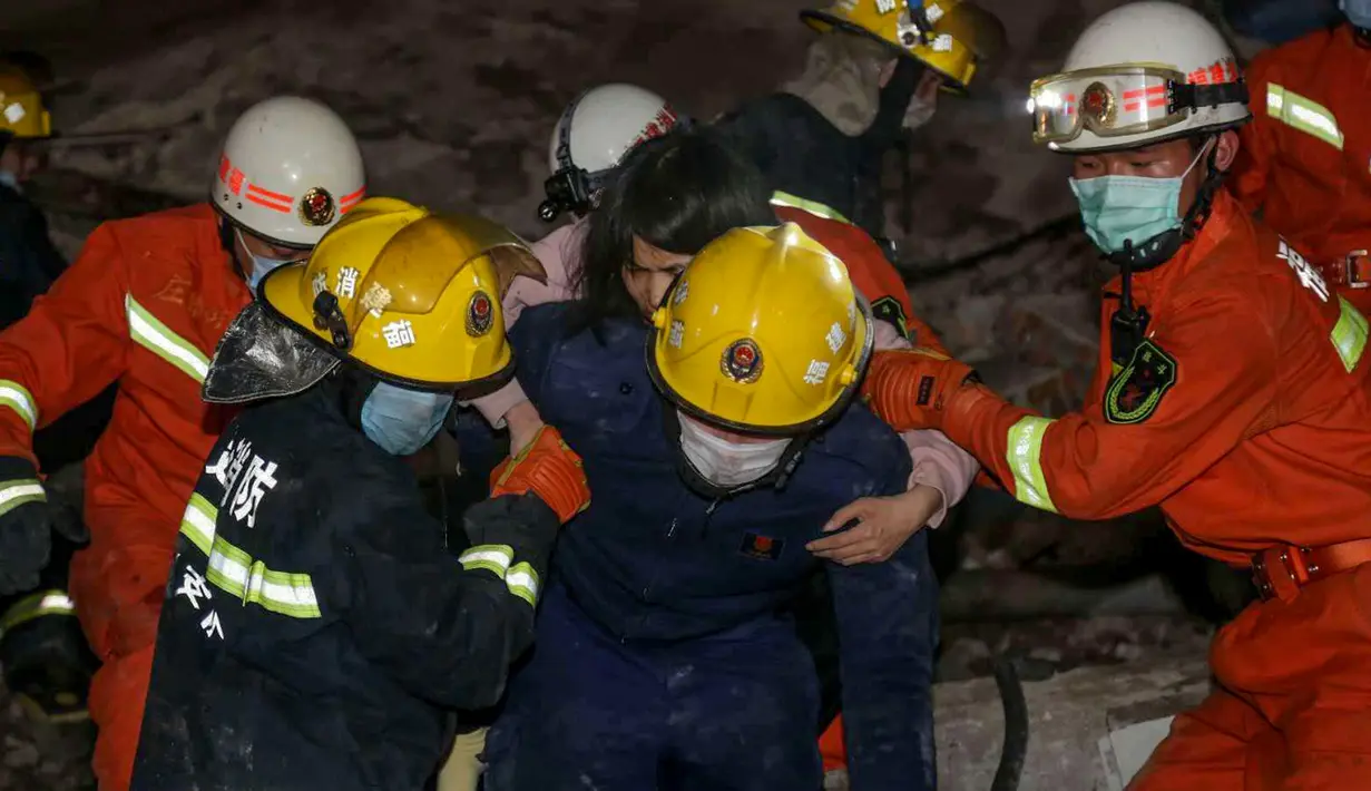 Seorang perempuan diselamatkan dari puing-puing sebuah hotel yang runtuh di Quanzhou, China, Sabtu (7/3/2020). Sekitar 70 orang terjebak di hotel Xinjia yang akhir-akhir ini digunakan sebagai tempat karantina untuk orang-orang yang berhubungan dengan pasien virus corona. (STR/AFP)