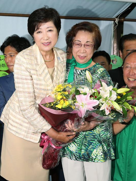 Yuriko Koike mendapat bunga saat merayakan kemenangannya sebagai Gubernur Tokyo, Jepang, Minggu (31/7). Yuriko terpilih menjadi wanita pertama yang memimpin ibukota Jepang. (AFP PHOTO / Jiji Press)