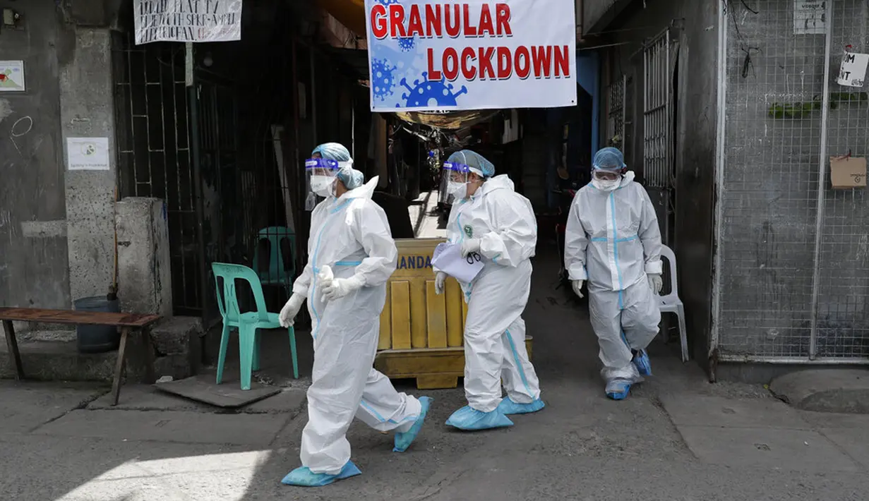 Petugas kesehatan mengenakan pakaian pelindung usai melakukan tes usap pada penduduk desa yang dilockdown untuk mencegah penyebaran COVID-19 di Manila, Filipina, Senin (15/3/2021). Kementerian Kesehatan Filipina melaporkan lonjakan kasus COVID-19 selama lebih dari seminggu. (AP Photo/Aaron Favila)