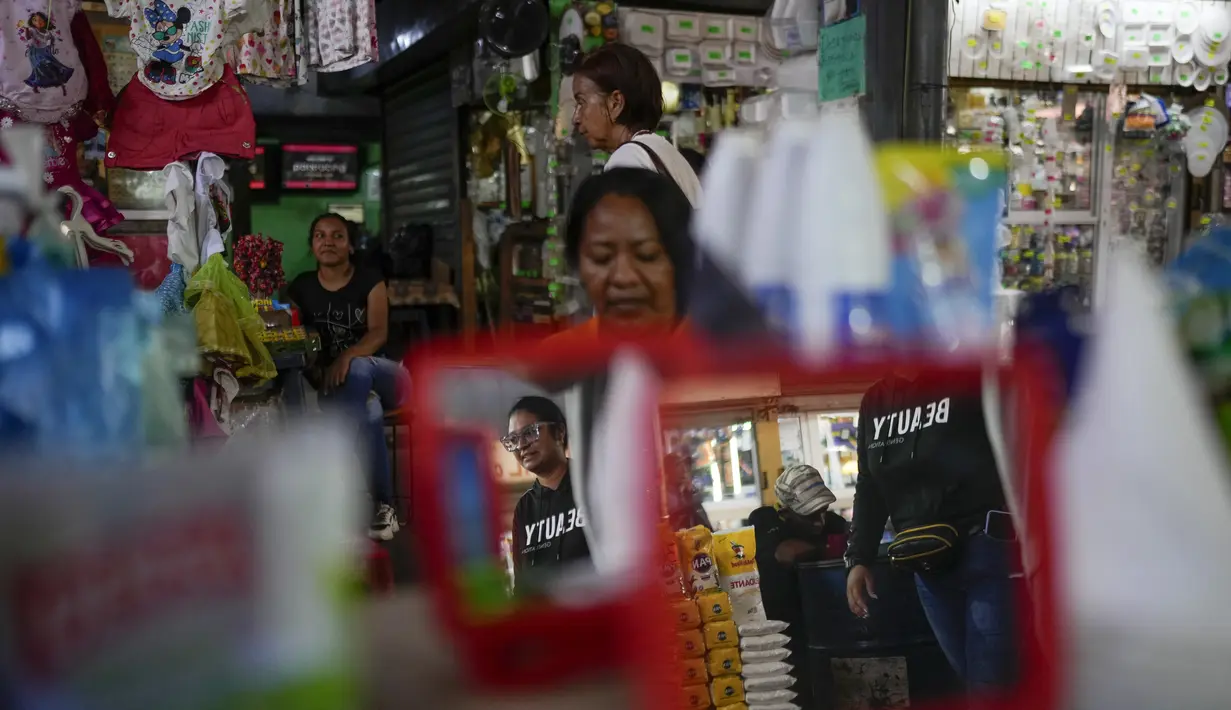 Orang-orang berjalan melalui pasar loak di Maracaibo, Venezuela, Senin, 22 Juli 2024. Venezuela telah mengumumkan akan mengadakan pemilihan presiden pada 28 Juli – beberapa bulan lebih awal dari perkiraan. (AP Photo/Matias Delacroix)