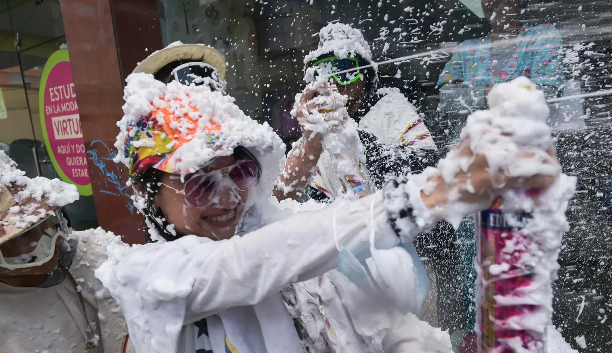 Orang-orang bermain dengan busa selama Karnaval Kulit Hitam dan Kulit Putih di Pasto, Kolombia pada tanggal 3 Januari 2024. (JOAQUIN SARMIENTO/AFP)