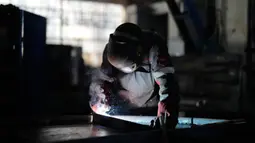 Seorang pekerja mengelas tempat berlindung di pabrik perusahaan Metinvest, Kryvyi Rih, Ukraina, 2 Maret 2023. Pabrik yang merupakan bagian dari perusahaan logam dan pertambangan Metinvest milik Renat Akhmetov, mengirimkan tempat perlindungan logam ke garis depan. (AP Photo/Thibault Camus)