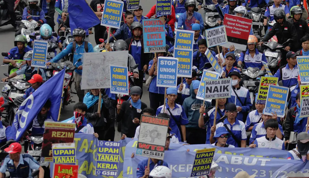 Ribuan buruh beratribut berwarna biru dan membawa spanduk terlihat berjalan memasuki Bundaran HI, Jakarta, Rabu (10/12/2014). (Liputan6.com/Faizal Fanani) 