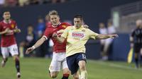 Gelandang Manchester United Bastian Schweinsteiger (kiri) mencoba merebut bola dari pemain Club America Pablo Cesar Aguilar, pada pertandingan International Champions Cup, di Seattle, 18 Juli 2015. (AFP PHOTO/STEPHEN BRASHEAR)