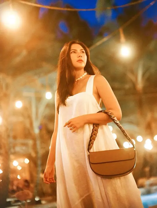 OOTD manis saat kamu liburan ke tempat dengan cuaca yang hangat, seperti terlihat dikenakan Jessica Mila di foto ini. Ia mengenakan simple dress tanpa lengan berwarna putih. Ia menyempurnakan penampilannya dengan kalung mutiara dan tas tangan berwarna cokelat. [Foto: Instagram/jsmila]