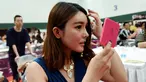 Seorang wanita merias diri saat mengikuti sebuah acara perjodohan di Hangzhou, Provinsi Zhejiang, China (14/5). Para Pria dan wanita mengikuti acara ini dengan harapan mendapatkan pasangan yang sesuai dengan kriterianya. (AFP Photo/Str/China Out)