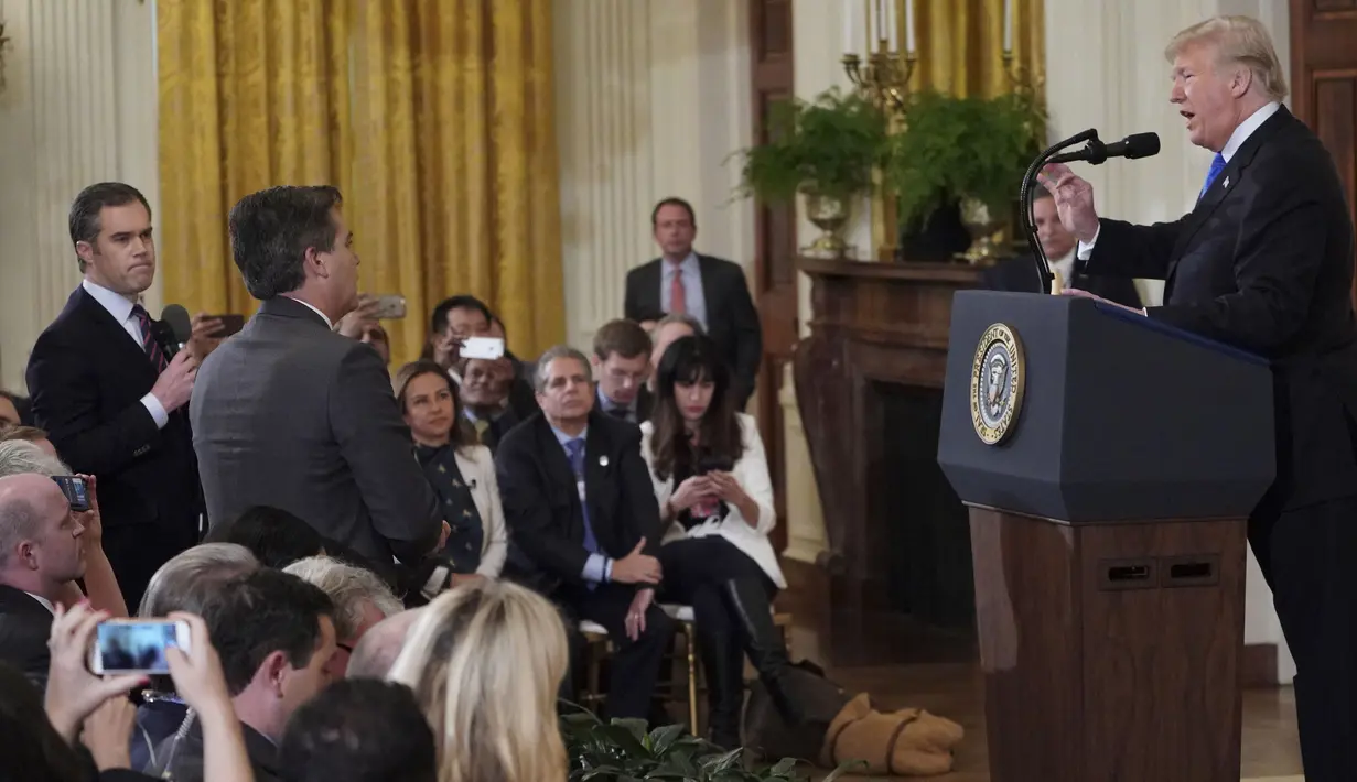 Presiden AS, Donald Trump terlibat adu mulut dengan jurnalis CNN, Jim Acosta (tengah) saat konferensi pers di Gedung Putih sesaat setelah pemilu sela digelar, Rabu (7/11). Ketegangan bermula dari pertanyaan sang wartawan soal imigran. (MANDEL NGAN/AFP)