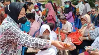 Risma membagikan bantuan untuk korban banjir Bangkalan. (Dian Kurniawan/Liputan6.com)