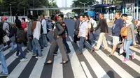 Warga melintasi Pelican Crossing di sekitar Halte Transjakarta Gelora Bung Karno, Jakarta, Jumat, (30/11). Ada tiga jembatan penyeberangan orang (JPO) di Jalan Jenderal Sudirman, Jakarta, yang sedang direvitalisasi. (Liputan6.com/Helmi Fithriansyah)