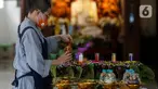 Petugas menyusun gelas lilin pelita menyambut perayaan Waisak di Wihara Ekayana Arama, Jakarta Barat, Selasa (25/5/2021). Wihara ini melakukan persiapan untuk menyambut rangkaian Hari Raya Waisak 2565 BE pada 26 Mei 2021 yang akan berlangsung secara virtual esok hari. (Liputan6.com/Johan Tallo)