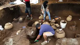 Pekerja Nicaraguan Institute of Culture (INC) menggali puluhan tembikar yang ditemukan di situs pemakaman zaman pra-Kolombia berusia lebih dari 1.200 tahun di lokasi pembangunan Stadion Bisbol Nasional yang baru di Managua, Selasa (20/6). (INTI OCON/AFP)