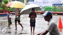 Bocah pengojek payung menunggu calon konsumen di tengah guyuran hujan, Jakarta, Selasa (1/11). Mereka mengenakan biaya jasa sewa payung mulai dari Rp.2000 hingga Rp.5000. (Liputan6.com/Angga Yuniar)