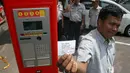 Seorang pengguna parkir menunjukkan tiket parkir meteran di Jalan Sabang, Menteng, Jakarta, (25/9/14). (Liputan6.com/Faizal Fanani) 