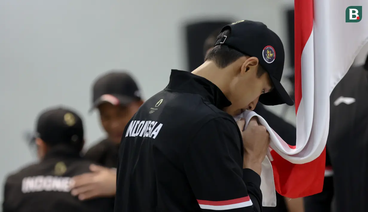 <p>Pebulu tangkis tunggal putra, Jonatan Christie mencium bendera Merah Putih dalam upacara Pengukuhan Kontingen Indonesia untuk Olimpiade Paris 2024 di Auditorium Wisma Kemenpora, Jakarta, Rabu (10/7/2024). Sebanyak 29 atlet akan mewakili Indonesia untuk berlaga dalam Olimpiade Paris 2024 pada 26 Juli hingga 11 Agustus 2024 mendatang. (Bola.com/Abdul Aziz)</p>