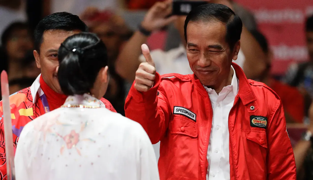 Presiden Joko Widodo memberi semangat kepada atlet wushu Lindswell Kwok saat beraksi pada Asian Games 2018 di JIExpo, Jakarta, Senin, (20/8). Lindswell meraih medali emas setelah berhasil mengumpulkan poin tertinggi yaitu 19.50. (AP Photo/Aaron Favila)
