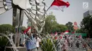 Massa Aliansi Masyarakat Indonesia Timur mengibarkan bendera Merah Putih saat berunjuk rasa di depan Istana Merdeka, Jakarta, Senin (2/9/2019). Massa menyatakan bahwa Papua tetap NKRI dan meminta pemerintah mengusut tuntas kasus rasis yang berujung konflik. (Liputan6.com/Faizal Fanani)