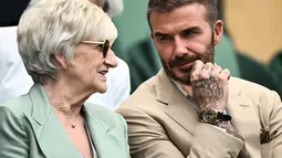 Mantan pemain sepak bola Inggris David Beckham dan ibunya Sandra Beckham duduk menyaksikan pertandingan kejuaraan tenis Wimbledon 2023 antara Daria Kasatkina dari Rusia dan Jodie Burrage dari Inggris di The All England Tennis Club di Wimbledon , London barat daya, pada 5 Juli 2023. (AFP/Sebastien Bozon)