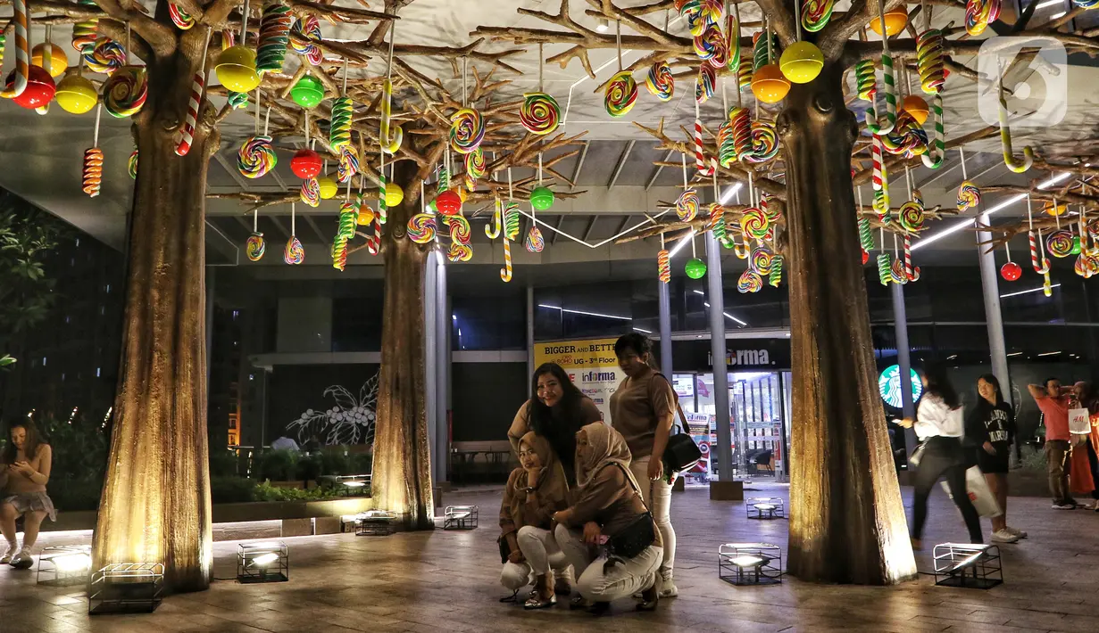 Pengunjung berfoto dengan dekorasi Natal menghiasi mal Central Park, Jakarta, Rabu (11/12/2019). Sejumlah pusat perbelanjaan di Jakarta mulai memasang dekorasi Natal untuk menarik minat pengunjung agar datang dan berbelanja. (Liputan6.com/Johan Tallo)