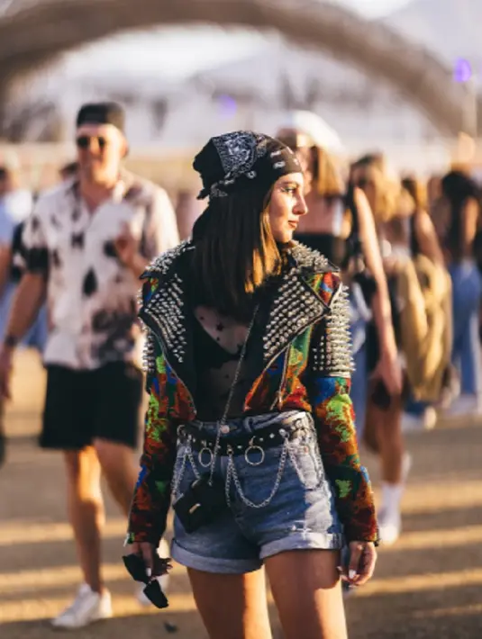 <p>Pengunjung yang satu ini memilih mengenakan black leather dengan studs, yang di baliknya, ia terlihat memakai sheer bodysuit dengan colorfull embellished moto jacket dan denim short. Foto: Bustle.</p>