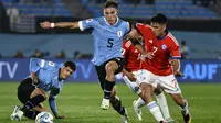 Gelandang Chile Marcelino Nunez, kanan, berbeut bola dengan gelandang Uruguay Manuel Ugarte  dalam Kualifikasi Piala Dunia 2026 zona CONMEBOL di Estadio Centenario, Sabtu (9/9/2023) pagi WIB. (AP Photo/Santiago Mazzarovich)