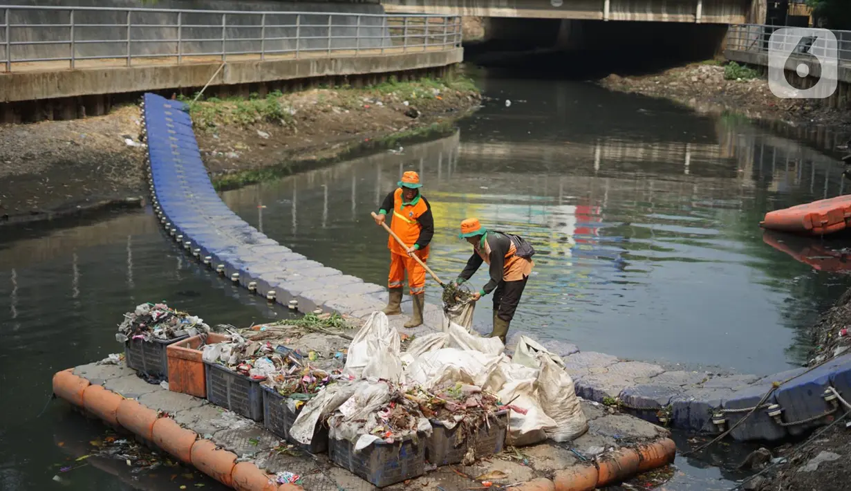 Petugas membersihkan sampah di sepanjang Kali Taman Anggrek, Jakarta, Rabu (8/7/2020). Banyaknya limbah menyebabkan Kali Taman Anggrek menjadi berwarna hitam dan berbau tidak sedap meskipun dibersihkan setiap hari. (Liputan6.com/Immanuel Antonius)