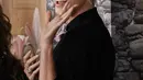 Charlize Theron melambaikan tangan saat tiba untuk pemutaran perdana film "The School for Good and Evil" di Regency Village Theatre di Los Angeles, California pada 18 Oktober 2022. Untuk beberapa bakat feminin, dia menempelkan hiasan bunga ke kerah. Tangannya dihiasi cincin perak yang serasi dengan susunan kancing dan lingkaran di telinganya. (AP Photo/Chris Pizzello)