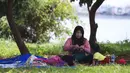 Seorang ibu bersama anaknya piknik di Taman Kota Waduk Pluit di Penjaringan, Jakarta Utara, Minggu (27/12/2020). Taman Kota Waduk Pluit dibuka kembali setelah ditutup pada libur Natal, namun banyak warga yang berwisata tidak menerapkan protokol kesehatan. (Liputan6.com/Johan Tallo)
