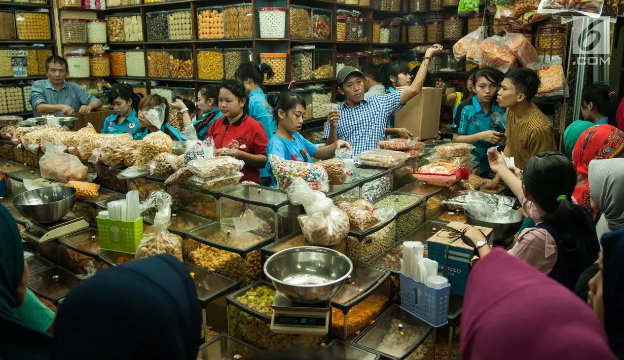 Penjual melayani pembeli kue kering di toko kue Pasar Jatinegara, Jakarta, Selasa (14/6). Untuk menarik minat pembeli, produsen kue kering juga setiap tahun menciptakan variasi kue-kue baru yang cita rasanya semakin inovatif. (Liputan6.com/Gempur M Surya)