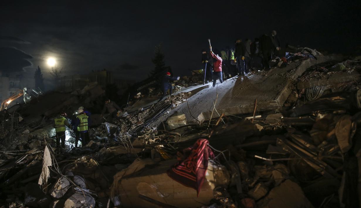Tim penyelamat mencari orang-orang di sebuah bangunan yang hancur, di Adiyaman, tenggara Turki, Rabu, 8 Februari 2023. Dengan harapan menemukan korban selamat memudar, tim penyelamat yang membentang di Turki dan Suriah pada Rabu masih mencari tanda-tanda kehidupan di antara puing-puing ribuan bangunan yang roboh akibat gempa paling mematikan di dunia dalam lebih dari satu dekade. (AP Photo/Emrah Gurel)
