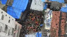 Petugas pemadam kebakaran India mencari korban setelah sebuah bangunan ambruk di Mumbai (16/7/2019). Dua orang tewas dan sedikitnya 40 terperangkap di bawah puing-puing setelah bangunan ambruk ketika hujan lebat. (AFP Photo/Punit Paranjpe)