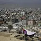 Seorang wanita menjemur pakaiannya di atap yang menghadap kota Kabul di Kabul, Afghanistan (28/11/2019). Puluhan ribu warga Afghanistan yang terlantar secara internal tinggal di kamp-kamp, yang kekurangan fasilitas dasar, di Afghanistan. (AP Photo/Altaf Qadri)