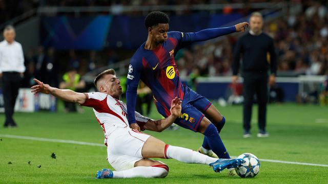 Pemain Olympiakos, Costinha (bawah), berusaha menghentikan pemain Barcelona, Alejandro Balde