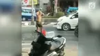 Seorang pemuda nekat mandi sekaligus keramas di tengah jalan. Belum diketahui maksud dari aksi tersebut.