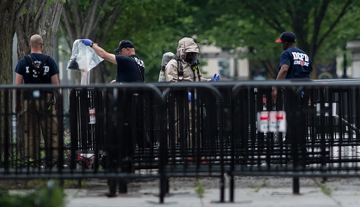 Tim penjinak bom diterjunkan setelah ditemukan sebuah benda mencurigakan di Gedung Putih, Washington, DC, Senin (30/5). Menurut laporan, seorang perempuan melemparkan sesuatu melewati pagar pembatas di bagian utara Gedung Putih. (Brendan Smialowski/AFP)