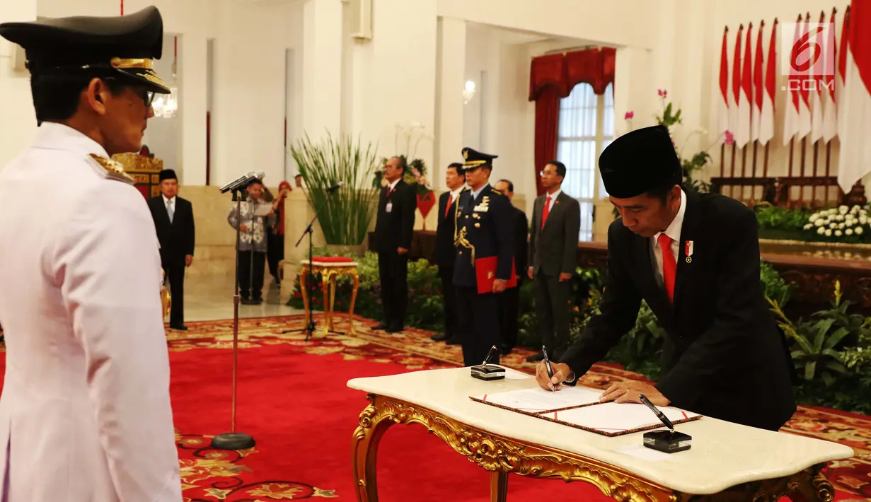 Presiden Joko Widodo menandatangangi berita acara saat pelantikan Sandiaga Uno sebagai Wakil Gubernur DKI Jakarta periode 2017-2022 di Istana Negara, Jakarta, Senin (16/10). (Liputan6.com/Angga Yuniar)