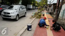 Pekerja menyelesaikan pembangunan Trotoar Ramah Disabilitas di Jalan Hidup Baru, Kalimati, Jakarta Utara, Selasa (27/12). Nantinya trotoar ini akan dibangun sepanjang 753 meter dan lebar 2,4 meter. (Liputan6.com/Gempur M. Surya)