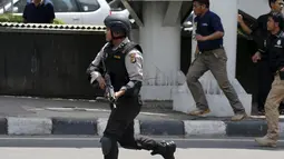 Seorang polisi Indonesia berjalan di dekat lokasi ledakan di Jakarta, Indonesia, (14/1/2016). Beberapa ledakan dan suara senjata api terjadi di pusat ibukota Indonesia, Polisi mencurigai seorang melakukan aksi bom bunuh diri. (REUTERS/Beawiharta)