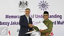 Dubes Inggris untuk Indonesia Moazzam Malik (kiri) bersama Ketua Umum PP Muhammadiyah Haedar Nasir melakukan penandatanganan nota kesepahaman di Jakarta, Senin (16/5). (Liputan6.com/Immanuel Antonius)