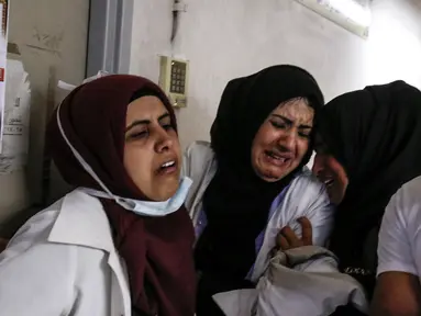 Perawat menangis atas kematian rekannya Razan al-Najjar di lorong rumah sakit Khan Yunis di Jalur Gaza selatan (1/6). Razan adalah sukarelawan Palestina berusia 21 tahun untuk kementerian kesehatan yang dikelola Hamas di Gaza. (AFP Photo/Kata Khatib)