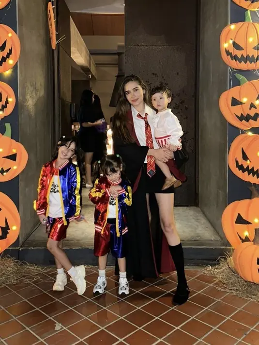 Yasmine Wildblood tampil menjadi karakter Harry Potter dengan jubah hitamnya. Kedua putrinya, Seraphina Rose dan Sophia Ayana memilih menjadi Harley Quinn. [@yaswildblood]