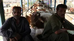 Pedagang menunggu untuk membongkar hewan ternak di pasar ternak yang disiapkan untuk menyambut Idul Adha di Karachi, Pakistan, Senin (14/9/2015). Muslim di seluruh dunia sedang mempersiapkan datangnya Hari Raya Idul Adha. (AFP PHOTO/RIZWAN Tabassum)
