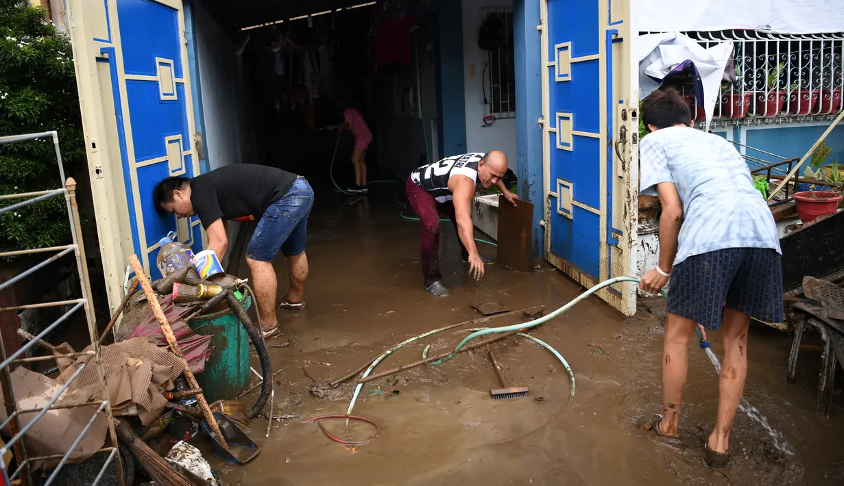Warga membersihkan rumah mereka setelah banjir akibat Topan Goni yang melanda Kota Batangas di selatan Manila, Filipina, Senin (2/11/2020). Goni, sebuah topan kategori 5 yang disebut-sebut sebagai topan terkuat sepanjang 2020, menghantam Filipina pada Minggu, 1 November 2020. (TED ALJIBE / AFP)
