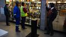 Pelanggan menunggu pembukaan kembali toko minuman keras ketika Afrika Selatan mencabut larangan penjualan alkohol dan rokok di Johannesburg, Selasa (18/8/2020). Pembelian alkohol dan rokok dilarang ketika Afrika Selatan memberlakukan lockdown ketat pada 27 Maret 2020. (AP Photo/Denis Farrell)