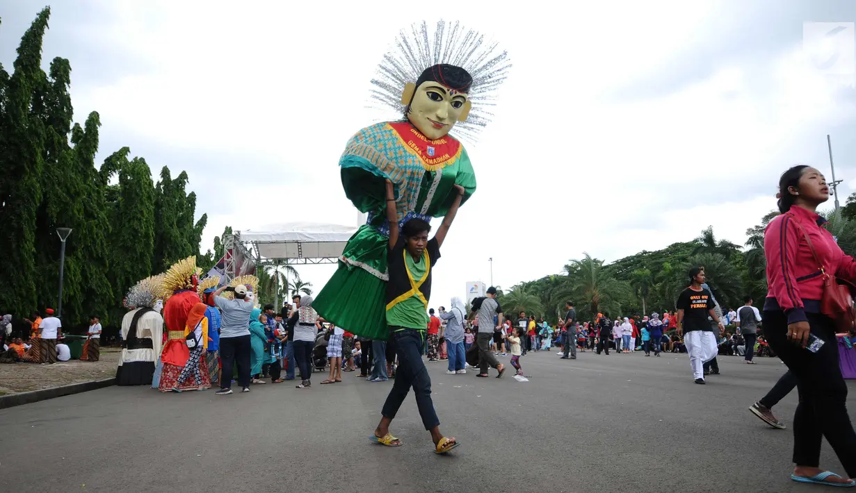 Warga mengangkat ondel-ondel di kawasan silang Monumen Nasional, Jakarta, Minggu (26/11). Deretan ondel-ondel ini bagian kemeriahan Kirab Kebangsaan yang diadakan Bamus Betawi. (Liputan6.com/Helmi Fithriansyah)