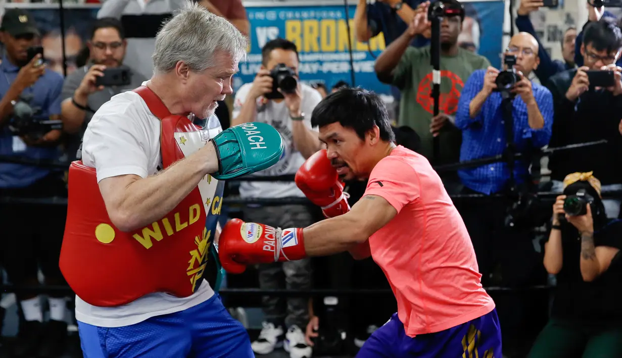 Petinju Manny Pacquiao (kanan) berlatih dengan pelatih Freddie Roach di sebuah klub tinju di Los Angeles, AS, Rabu (9/1). Pertarungan melawan Adrien Broner menjadi duel tinju profesional ke-70 bagi Manny Pacquiao. (AP Photo/Damian Dovarganes)