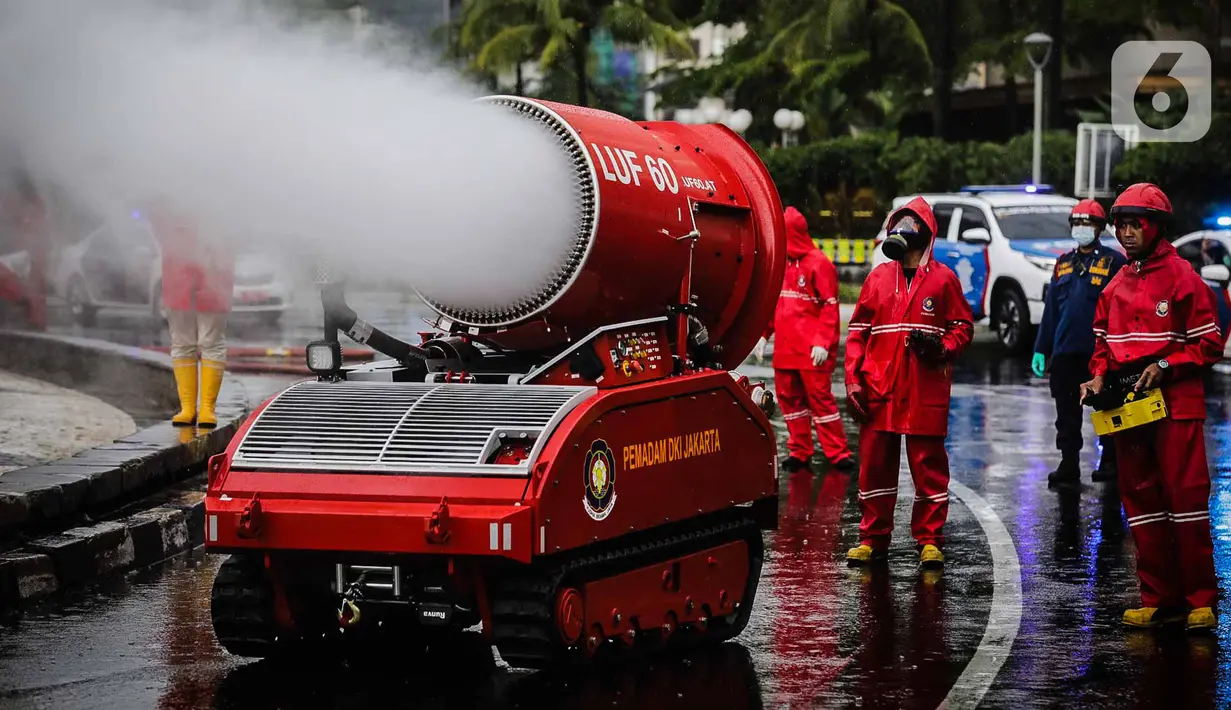 Petugas pemadam kebakaran menyemprotkan cairan disinfektan menggunakan robot LUF 60 di kawasan Bundaran HI, Jakarta, Minggu (22/3/2020). Pemprov DKI Jakarta melakukan penyemprotan fasilitas umum untuk mencegah penyebaran virus corona COVID-19. (Liputan6.com/Faizal Fanani)