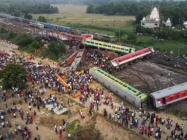 Orang-orang berkumpul di lokasi kecelakaan tabrakan tiga kereta di dekat Balasore, sekitar 200 km (125 mil) dari ibu kota negara bagian Bhubaneswar di negara bagian timur Odisha. (Jayanta SHAW/AFPTV/AFP)